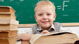 Schüler mit Büchern vor der Tafel