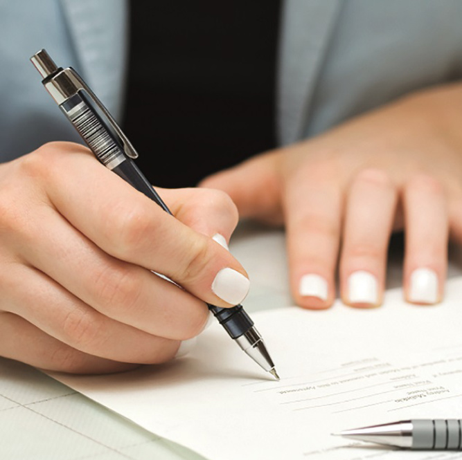 Eine Frauenhand, die ein Formular ausfüllt