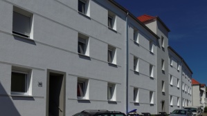 Sanierte Wohnhäuser mit drei Etagen an einer Straße, helle Fassade. Sanierte Wohnhäuser mit drei Etagen an einer Straße, helle Fassade.