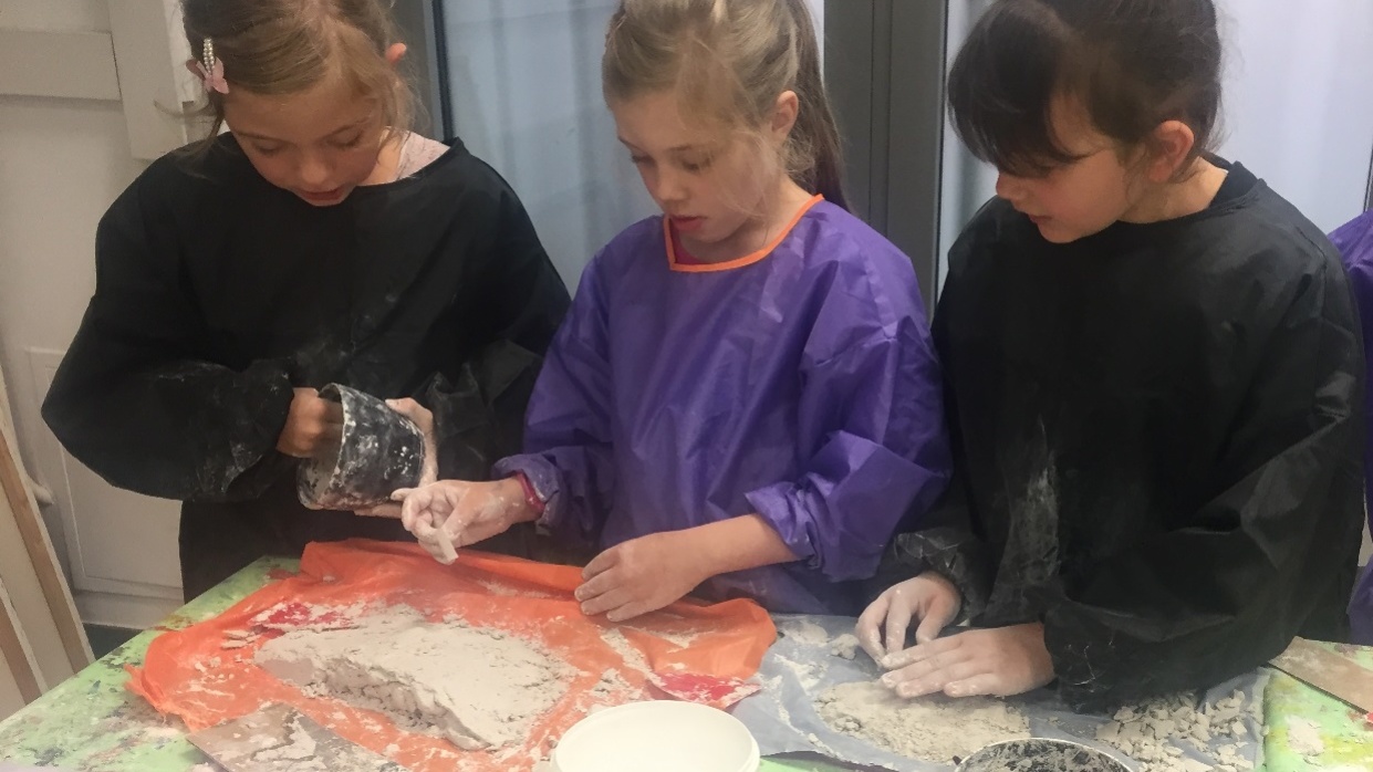 Drei Mädchen kneten Gipsmasse durch