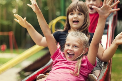 Kinder rutschen auf einem Spielplatz (Foto: gpointstudio/shutterstock)