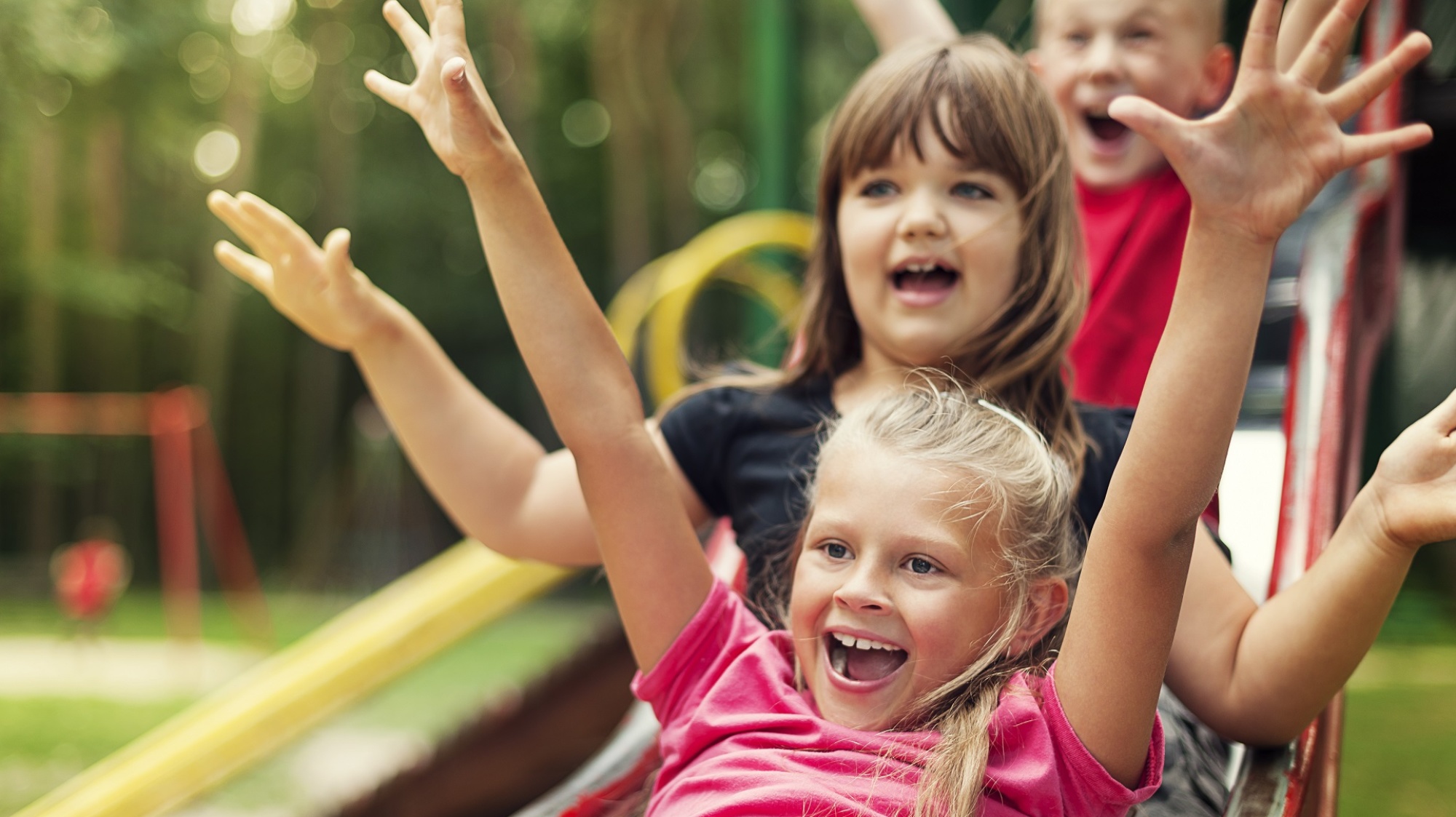 Kinder rutschen auf einem Spielplatz (Foto: gpointstudio/shutterstock)