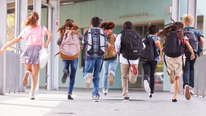 Kinder laufen im Schulgebäude (