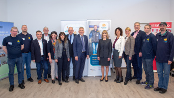 Im Rahmen einer Pressekonferenz stellten Landrat Patrik Lauer (in der Mitte), mobisaar-Projektkoordinatorin Katharina Meßner-Schalk von der Saarbahn GmbH (in der Mitte), Professor Daniel Bieber iso-Institut (7. v. l.), Sozialdezernentin Susanne Schwarz, Schwarz (5. v. l.), Geschäftsführer der KVS GmbH Andreas Michel (3. v. l.), Oberbürgermeister Peter Demmer (4. v. l.), Geschäftsführerin der SNS GmbH Elke Schmidt (6. v. l.), Ingrid Wacht vom Sozialverband VdK (5. v. r.), Kristina Lemke von LAG pro Ehrenamt (4. v. r.) und Bürgermeister Stefan Louis (3. v. r.)  – eingerahmt von den mobisaar-Lotsen der BQ  – das am 15. Mai 2019 im Landkreis Saarlouis startende Projekt „mobisaar“ vor.