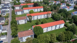 sanierte Wohnhäuser mit 3 Etagen, Satteldächern, helle Fassaden. Rundum Grünflächen mit Bäumen sanierte Wohnhäuser mit 3 Etagen, Satteldächern, helle Fassaden. Rundum Grünflächen mit Bäumen