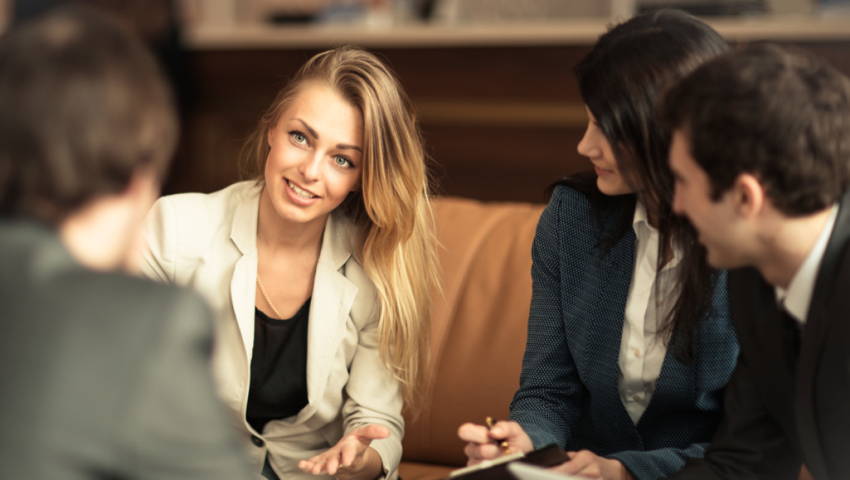 Frau mit mehreren Personen in einer Besprechung