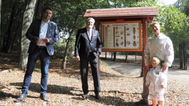 OB Uwe Conradt, Sparkassenvorstand Uwe Kuntz, Adrian Höber mit Tochter Martha von der Wildparkakademie vor neuer Bienentafel Image