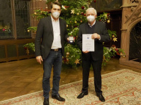 OB Conradt und Rudolf Kraus mit Urkunde und Bürgermdaille vor dem Weihnachtsbaum im Rathausfestsaal
