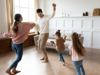 Eltern und Kinder tanzen durch das Wohnzimmer