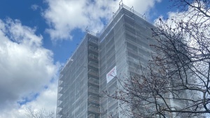 Obere Stockwerke eines Hochhauses, 12 Wohnetagen, mit Baugerüst und Netzen Obere Stockwerke eines Hochhauses, 12 Wohnetagen, mit Baugerüst und Netzen