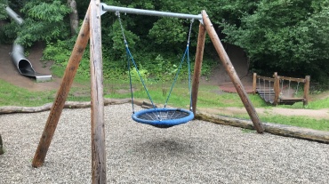 Schaukel mit Röhrenrutsche im Hintergrund Image