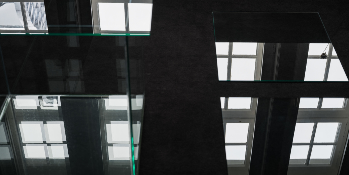 Reflexionen von Fenstern und Tageslicht in Glasscheiben in einem schwarzen Raum