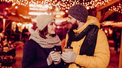 Couple sur un marché de Noël Une femme et un homme sur un marché de Noël