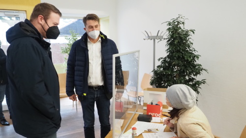 Oberbürgermeister Uwe Conradt und Dezernent Tobias Raab sind an der Anmeldung der Impfstation am St. Johanner Markt.