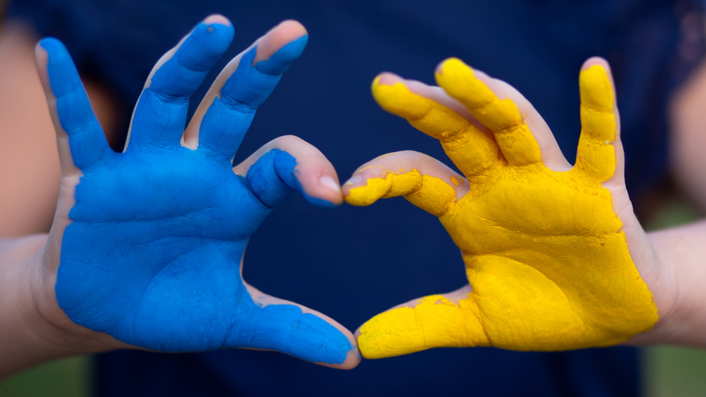 Herz aus Händen blau und gelb