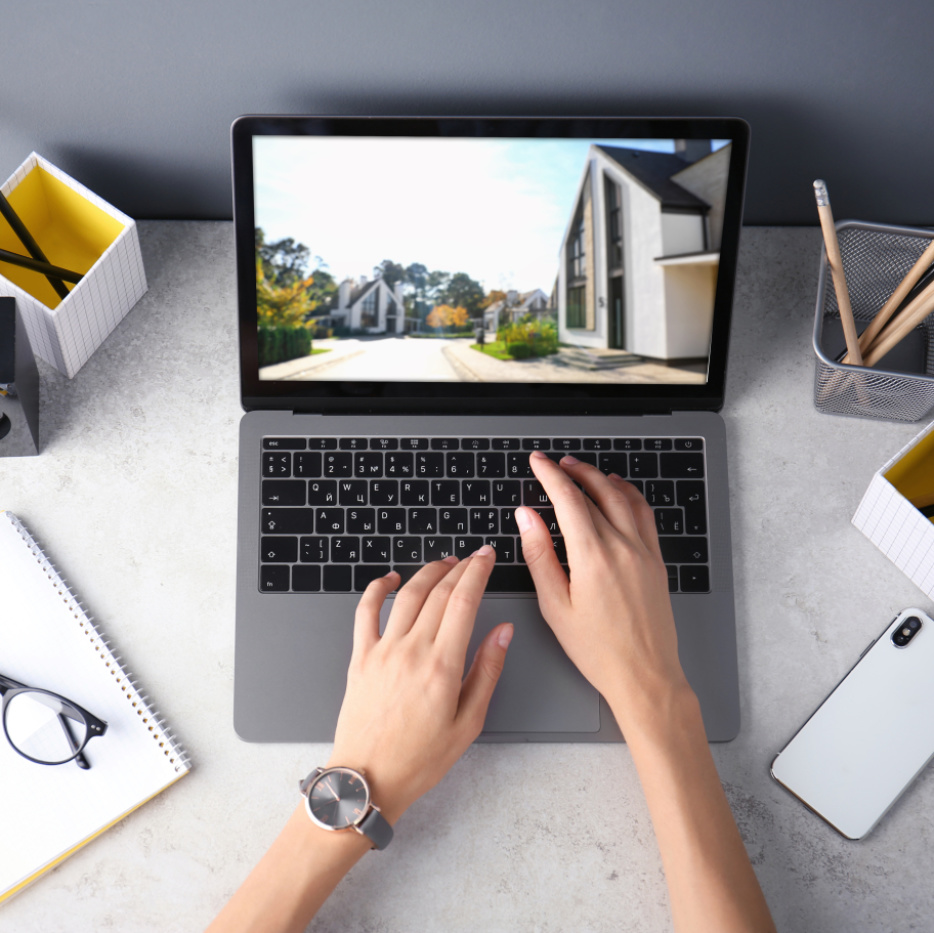 Zwei Hände tippen auf einem Laptop