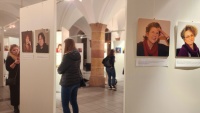 Blick in den Hauberrisser Saal mit Besucherinnen vor weißen Stellwänden, auf denen Portraits zu sehen sind