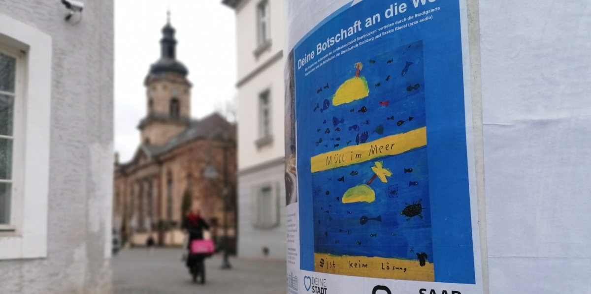 Plakat von Kindern in blau an einer Lifaßsäule