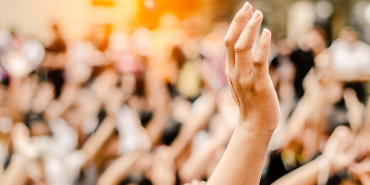 Symbolbild Bürgerbeteiligung mit erhobener Hand in der Menge