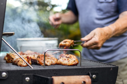 Mann grillt Fleisch