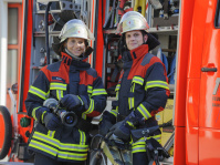 Feuerwehrfrau und Feuerwehrmann in Ausrüstung 