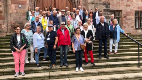 Eine Gruppe von Senioren steht vor der Basilika in Saarbrücken