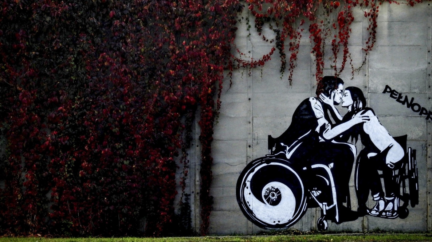 Paar im Rollstuhl küsst sich