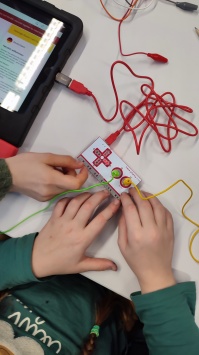 Makey Makey Kinderhände stecken Verbindungen auf der Leiterplatine