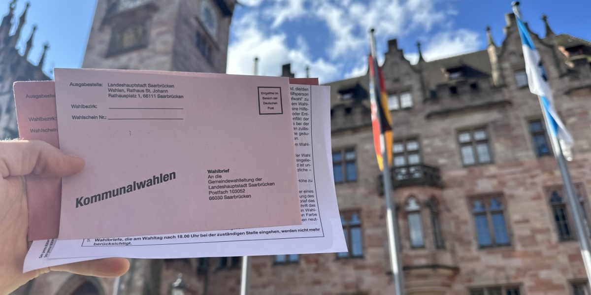 Symboldbild Kommunalwahlen 2024 vor dem Rathaus Saarbrücken mit Stimmzettel