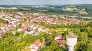 Kleiner Turm am Waldrand neben Dorf