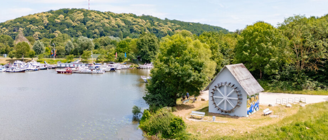 Kleines Gebäude am Wasser mit Booten im Hintergund