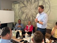 Politiker-Presse-Frühstück im Rahmen der 16. Hoffeste im Quartier Mainzer Straße Eine Person steht, um sie herum sitzen mehrere Personen an einem Tisch.