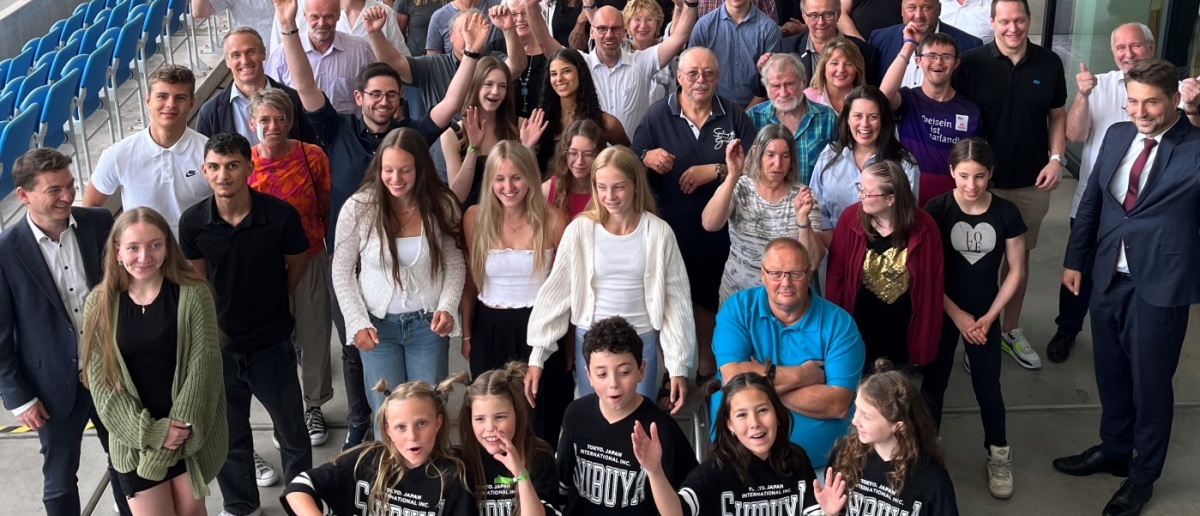 Eine große Gruppe Sportler lachend neben OB Conradt