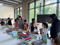 Kinder suchen sich Bücher aus auf Büchertisch