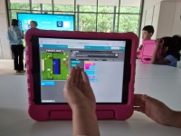 Kinder programmieren mit Dozenten an Tablets