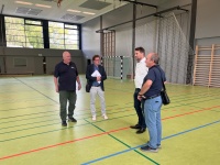 Vier Personen stehen in einer Sporthalle