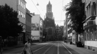 Schwarz-weiß Fotografie der Großherzog-Friedrich-Straße mit einer Fußgängerin und Blick auf das Rathaus St. Johann