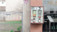 Kaugummiautomat an einer rosa-grauen Wand