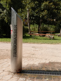 Eine metallische Stele in grüner Umgebung