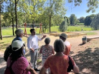 Eine Gruppe Menschen vor einem Spielplatz im Grünen