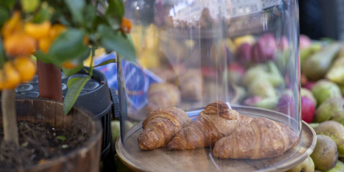 Festmeile der Landeshauptstadt beim Tag der Deutschen Einheit 2025 Zwei Croissants unter Glasglocke auf Marktstand, dahinter Früchte