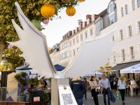Fotopoint mit weißen Flügeln, dahinter Lampions im Baum