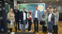 Gruppe von Menschen posiert gemeinsam vor Messewand