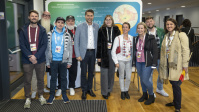 Gruppe von Menschen posiert gemeinsam vor Messewand