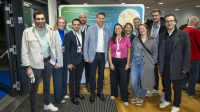 Gruppe von Menschen posiert gemeinsam vor Messewand