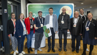 Gruppe von Menschen posiert gemeinsam vor Messewand