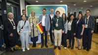 Gruppe von Menschen posiert gemeinsam vor Messewand