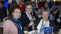 Drei Frauen mit Wein an Stehtisch