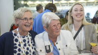 Drei Frauen lachen gemeinsam bei Empfangsrunde