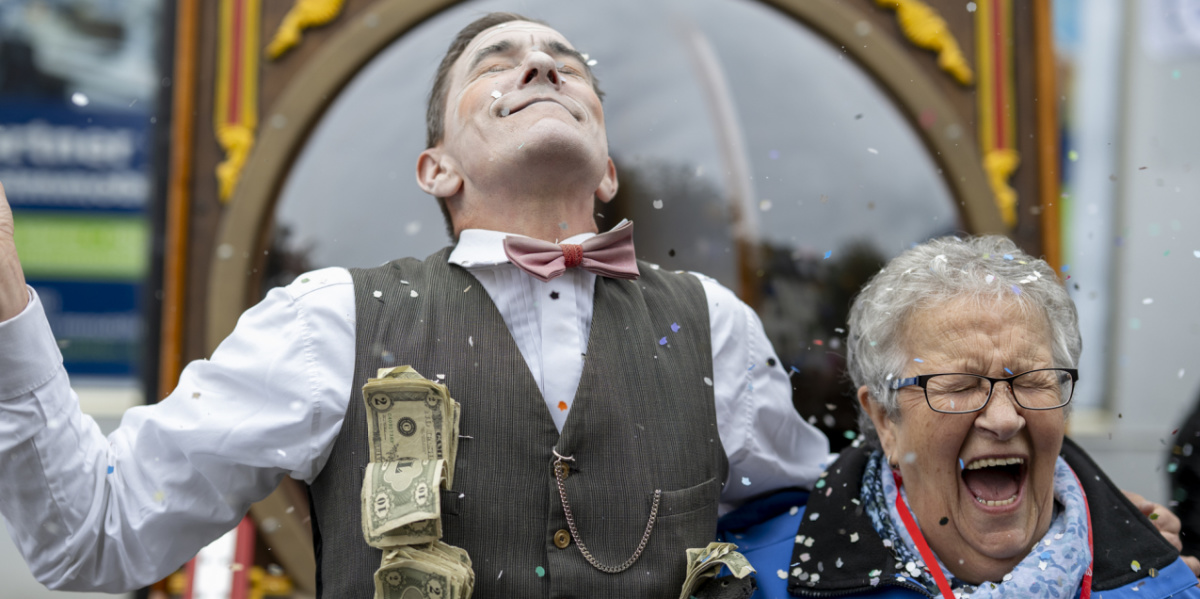 Festmeile der Landeshauptstadt beim Tag der Deutschen Einheit 2025 Schauspieler mit Geldscheinen jubelt neben lachender Frau